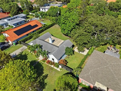an aerial view of residential house with outdoor space and trees all around