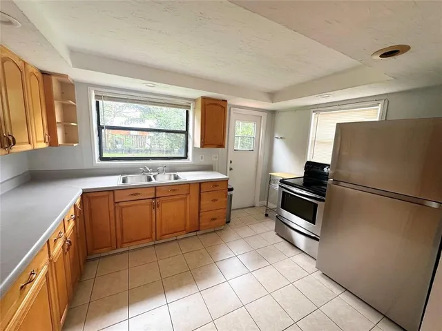 a kitchen with stainless steel appliances a refrigerator sink and microwave