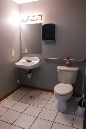 a bathroom with a sink toilet and a mirror