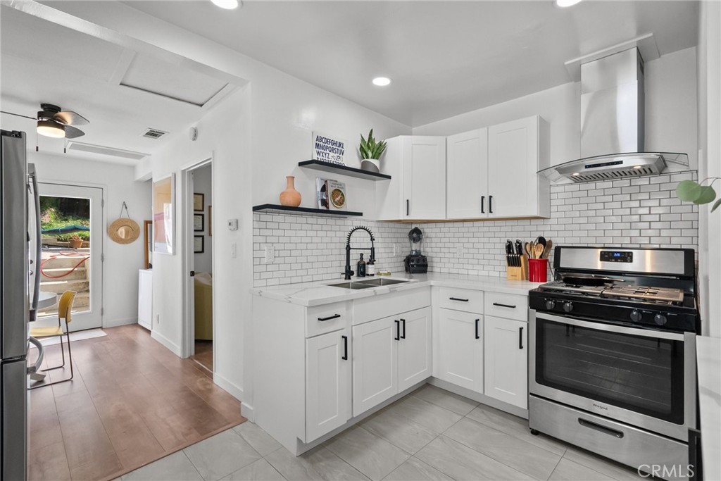 a kitchen with stainless steel appliances a stove sink and cabinets