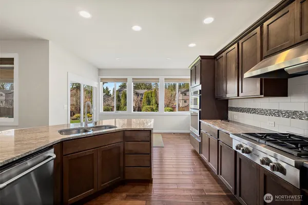 a kitchen with stainless steel appliances a sink stove and cabinets