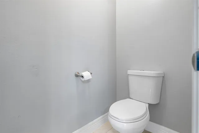 a white toilet sitting next to a white walls