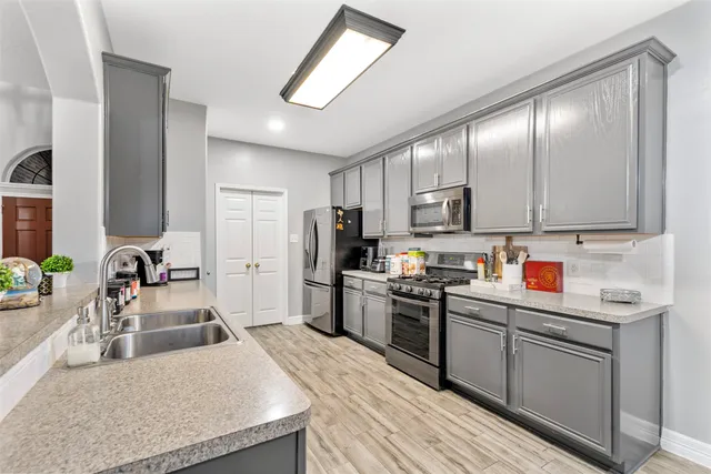 a kitchen with stainless steel appliances granite countertop a sink dishwasher stove refrigerator and cabinets