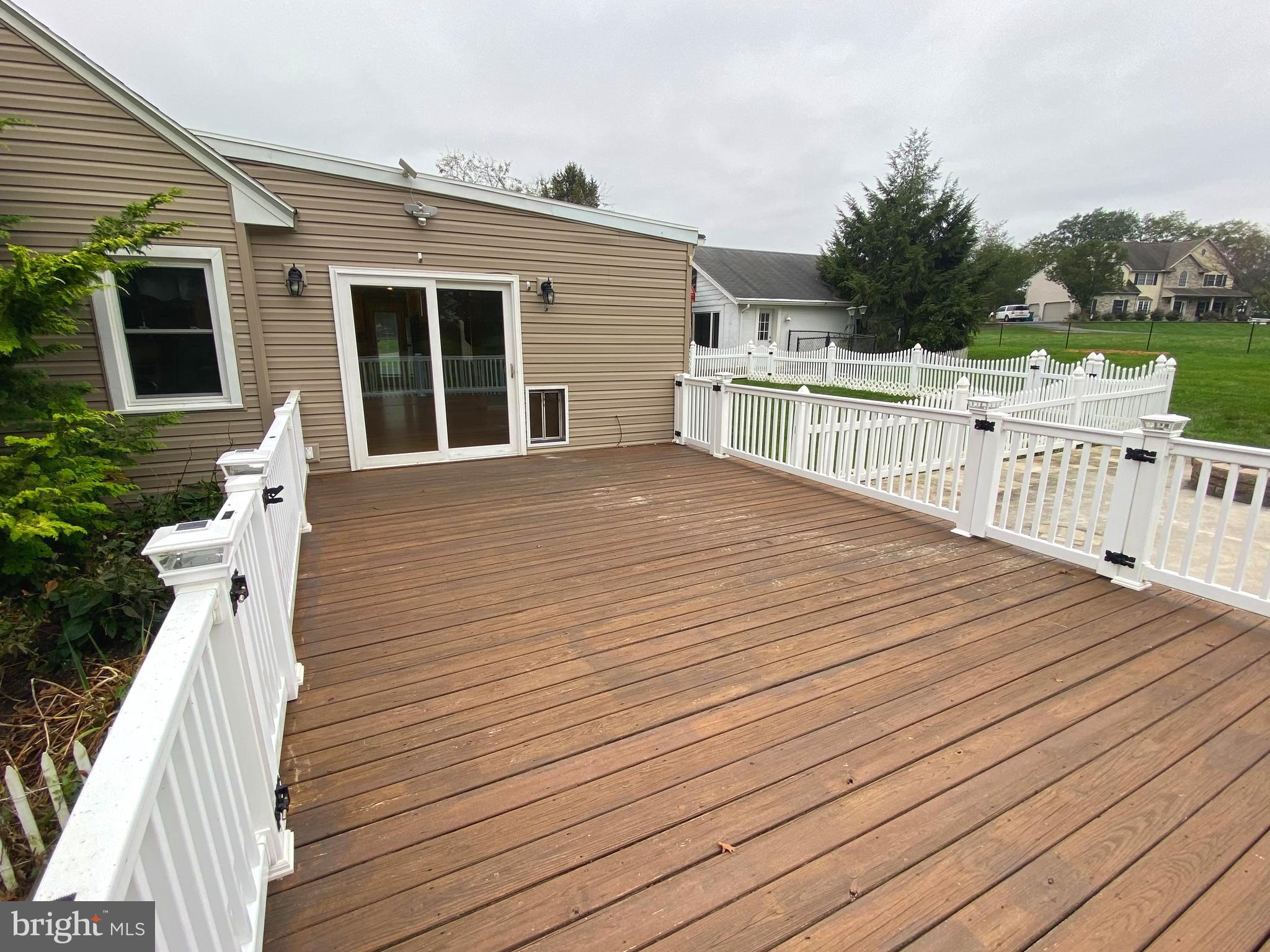 Wooden deck with vinyl railings.