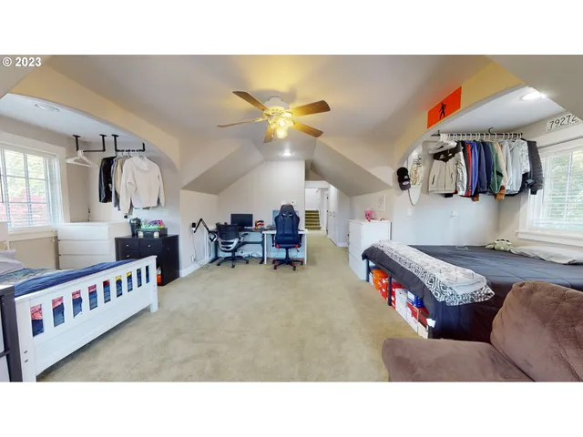 a living room with a bed furniture and next to a window