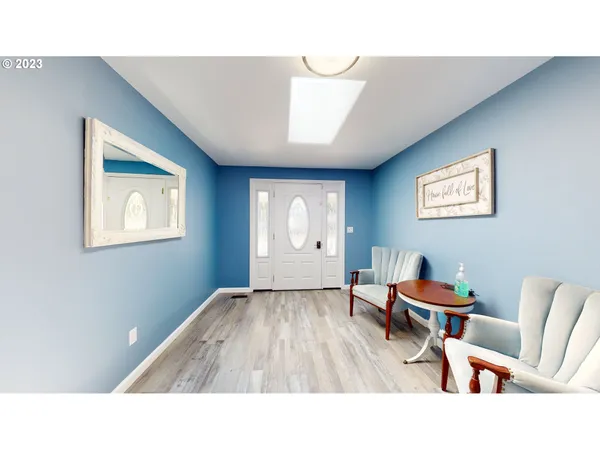 a dining room with wooden floor a chandelier a wooden table and chairs