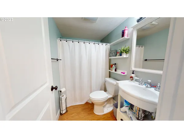 a bathroom with a sink toilet a mirror and shower