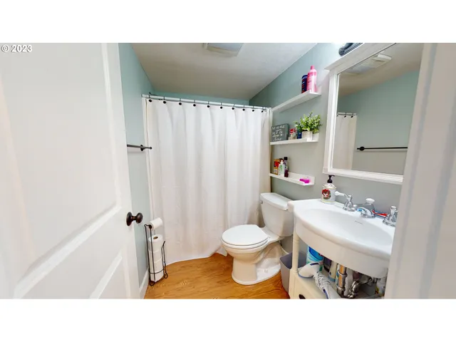 a bathroom with a sink toilet a mirror and shower