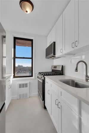 a kitchen with white cabinets and sink