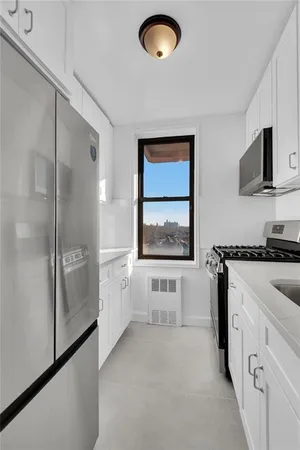 a view of kitchen with stainless steel appliances cabinets and a window