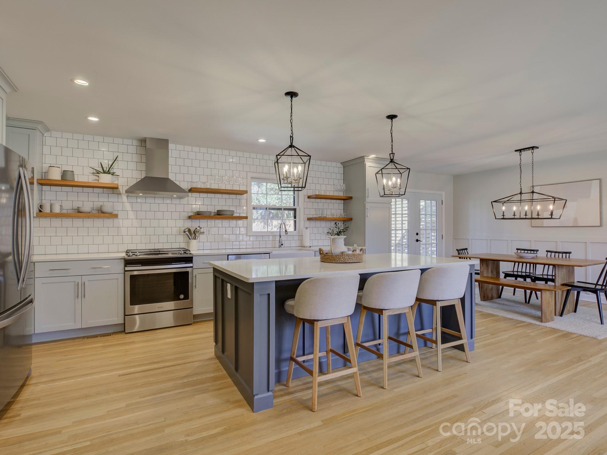 1225 Braeburn Road Charlotte, NC 28211 - Photo 15 of 45 a kitchen with stainless steel appliances granite countertop a stove top oven a sink dishwasher a dining table and chairs with wooden floor