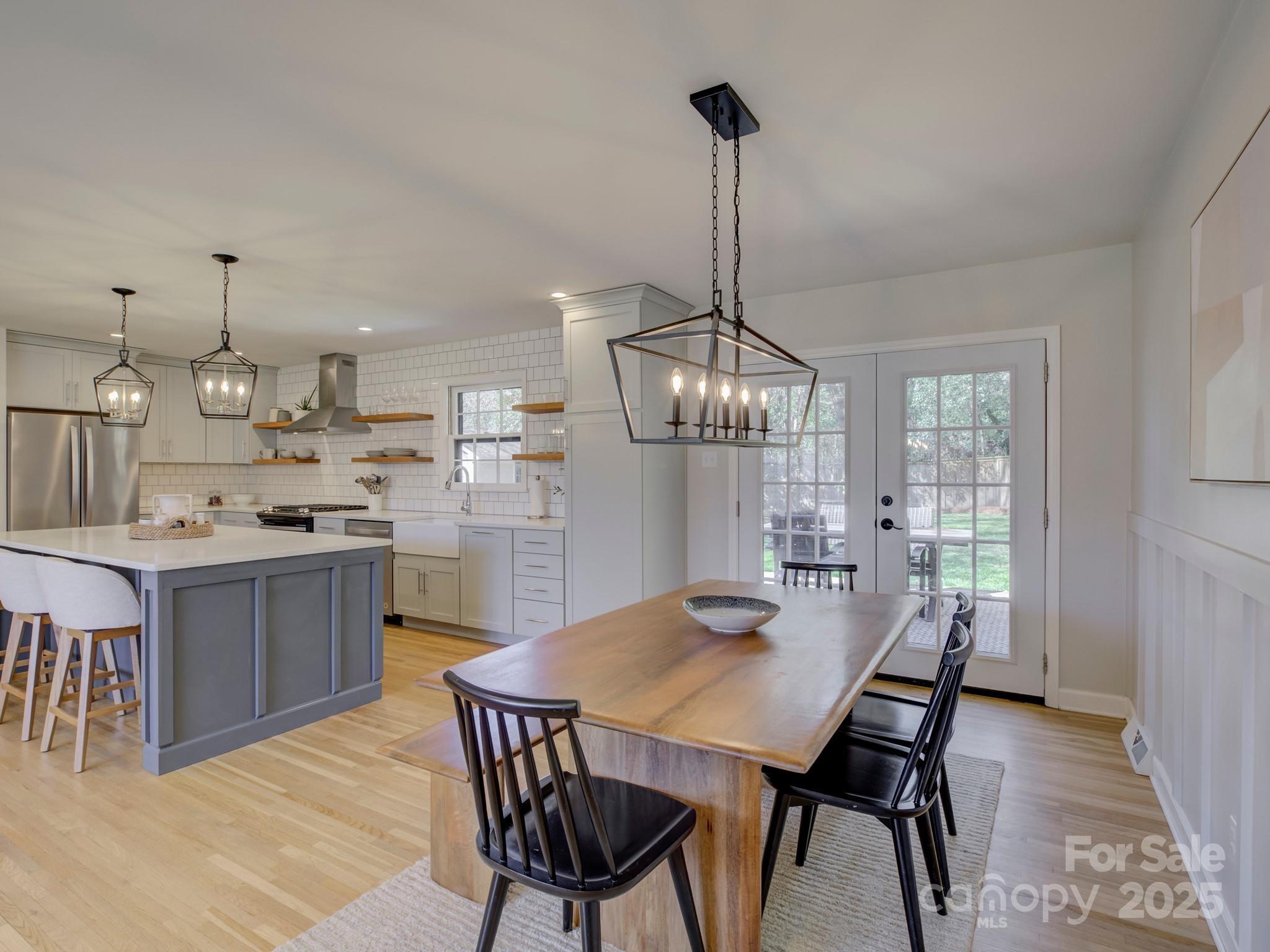 1225 Braeburn Road Charlotte, NC 28211 - Photo 21 of 45 a kitchen with stainless steel appliances kitchen island a dining table chairs and white cabinets