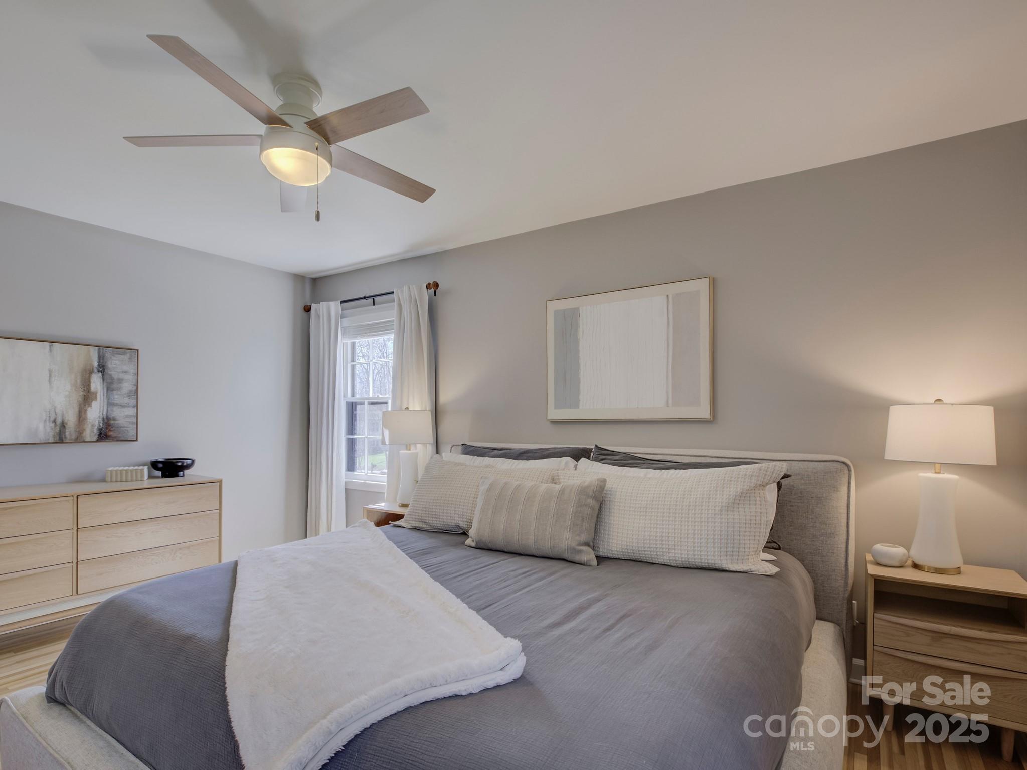 1225 Braeburn Road Charlotte, NC 28211 - Photo 30 of 45 a bedroom with a large bed and a chandelier