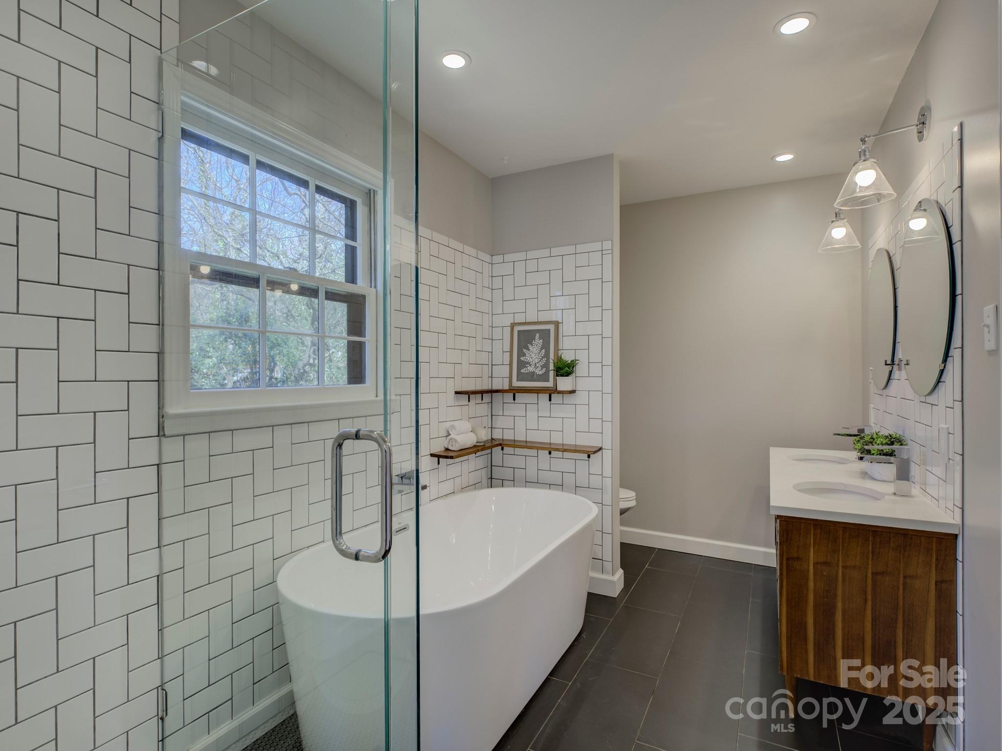 1225 Braeburn Road Charlotte, NC 28211 - Photo 31 of 45 a bathroom with a sink a bathtub and next to a window