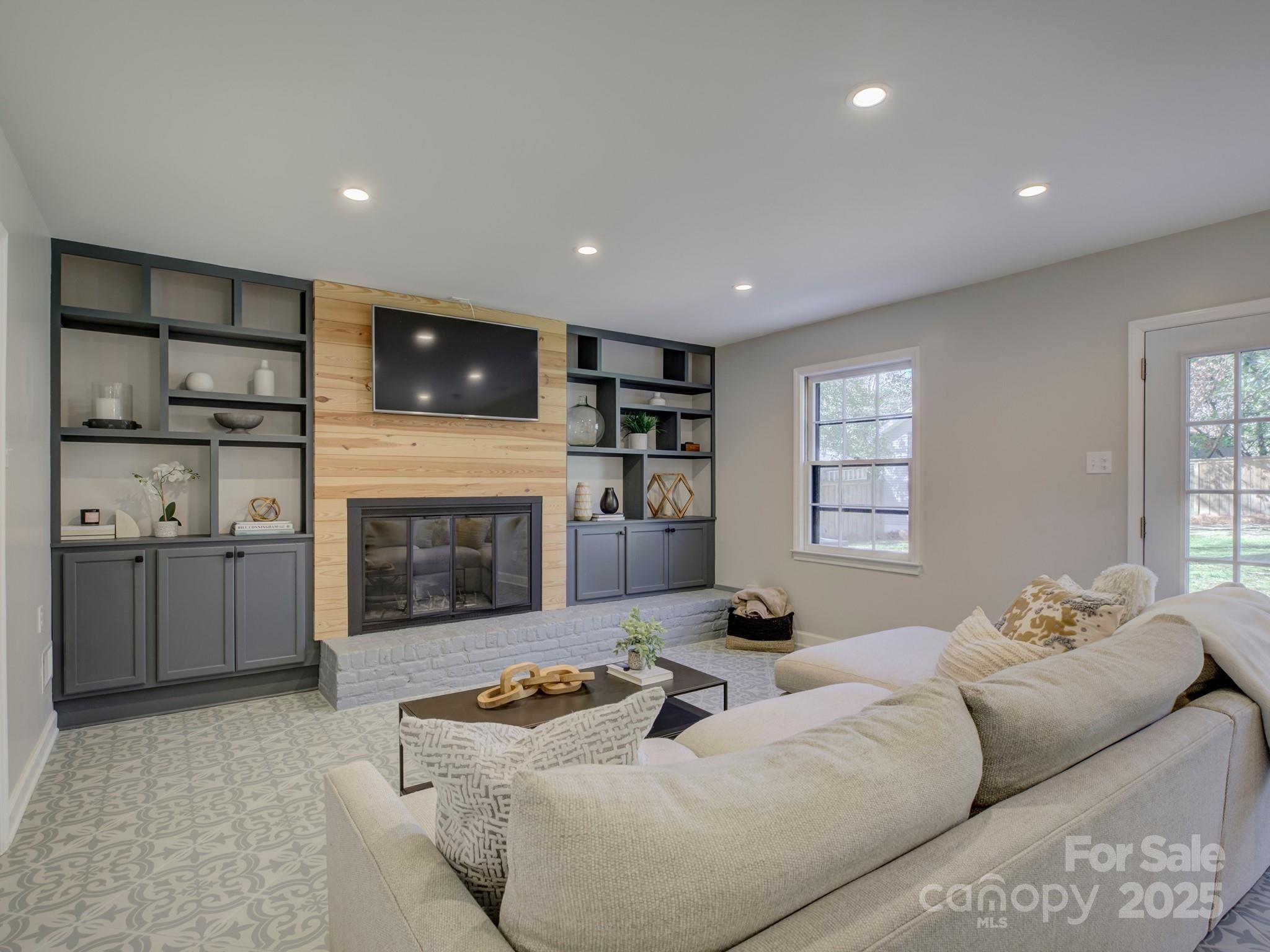 1225 Braeburn Road Charlotte, NC 28211 - Photo 6 of 45 a living room with furniture a fireplace and a flat screen tv