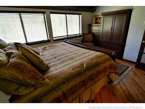 1944 Soda Ridge Road, Unit 229 Keystone, CO 80435 - Photo 16 of 25 a bedroom with a bed and wooden floor