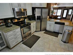 1944 Soda Ridge Road, Unit 229 Keystone, CO 80435 - Photo 4 of 25 a kitchen with stainless steel appliances kitchen island granite countertop a stove a sink and a microwave
