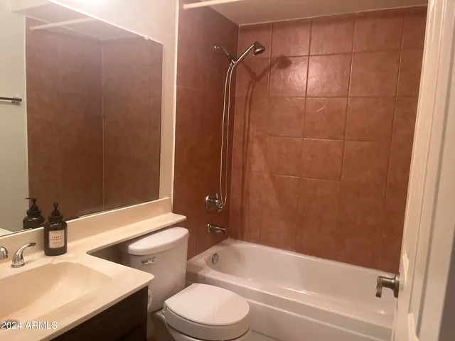 a bathroom with a bathtub shower sink vanity and toilet
