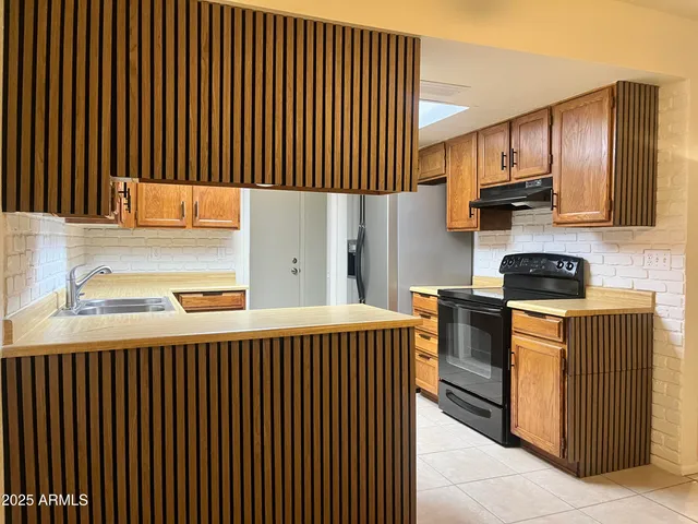 a kitchen with stainless steel appliances granite countertop wooden cabinets a stove top oven a sink and dishwasher