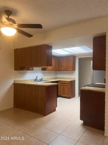 a kitchen with kitchen island granite countertop a stove a sink and a microwave