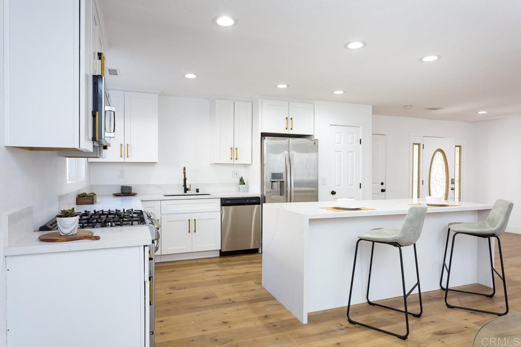 a kitchen with a sink a refrigerator and white cabinets