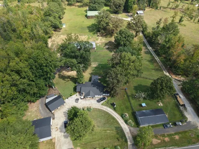 an aerial view of residential houses with outdoor space and trees