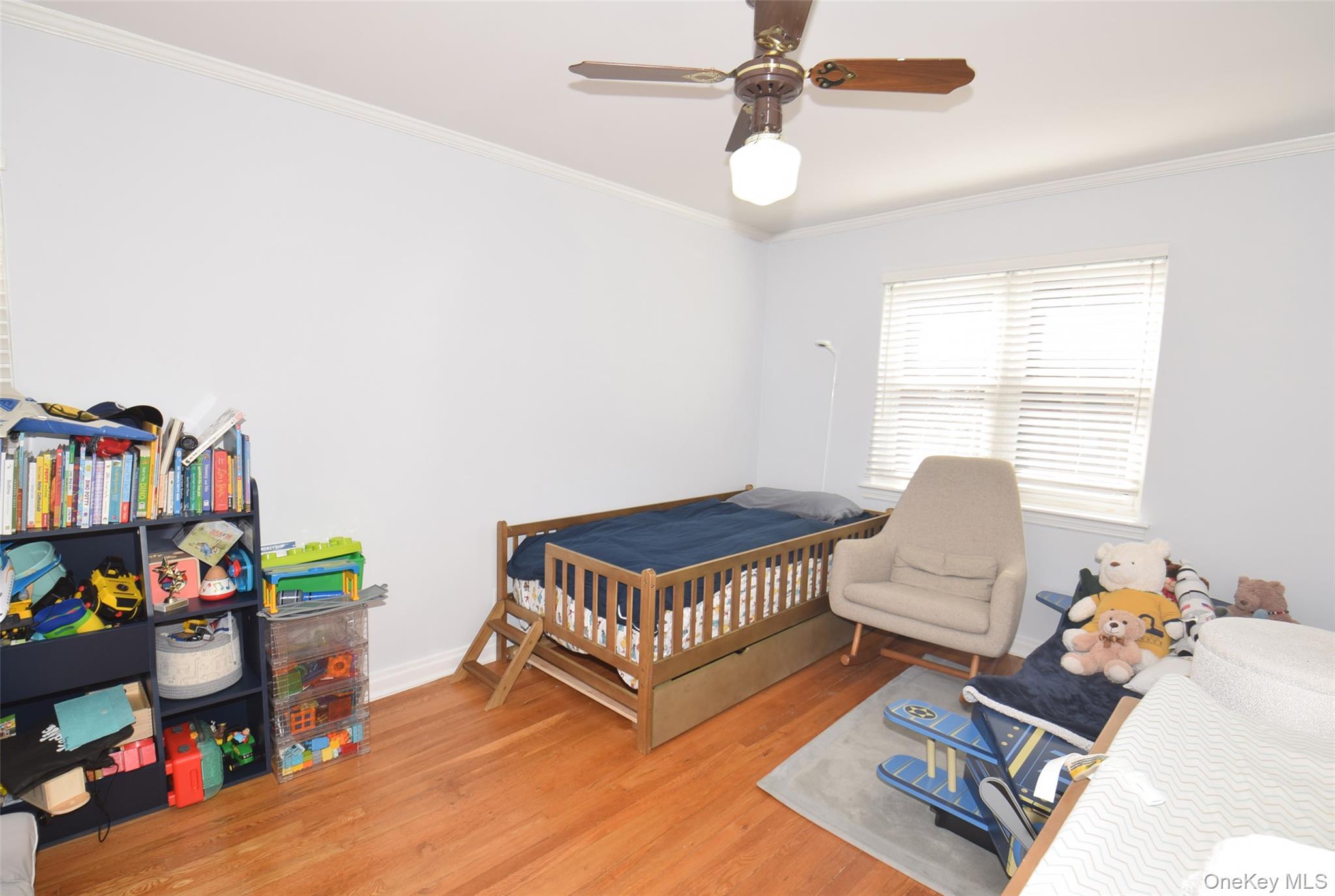 105-48 65th Road Queens, NY 11375 - Photo 11 of 17 a living room with lots of furniture and a book shelf