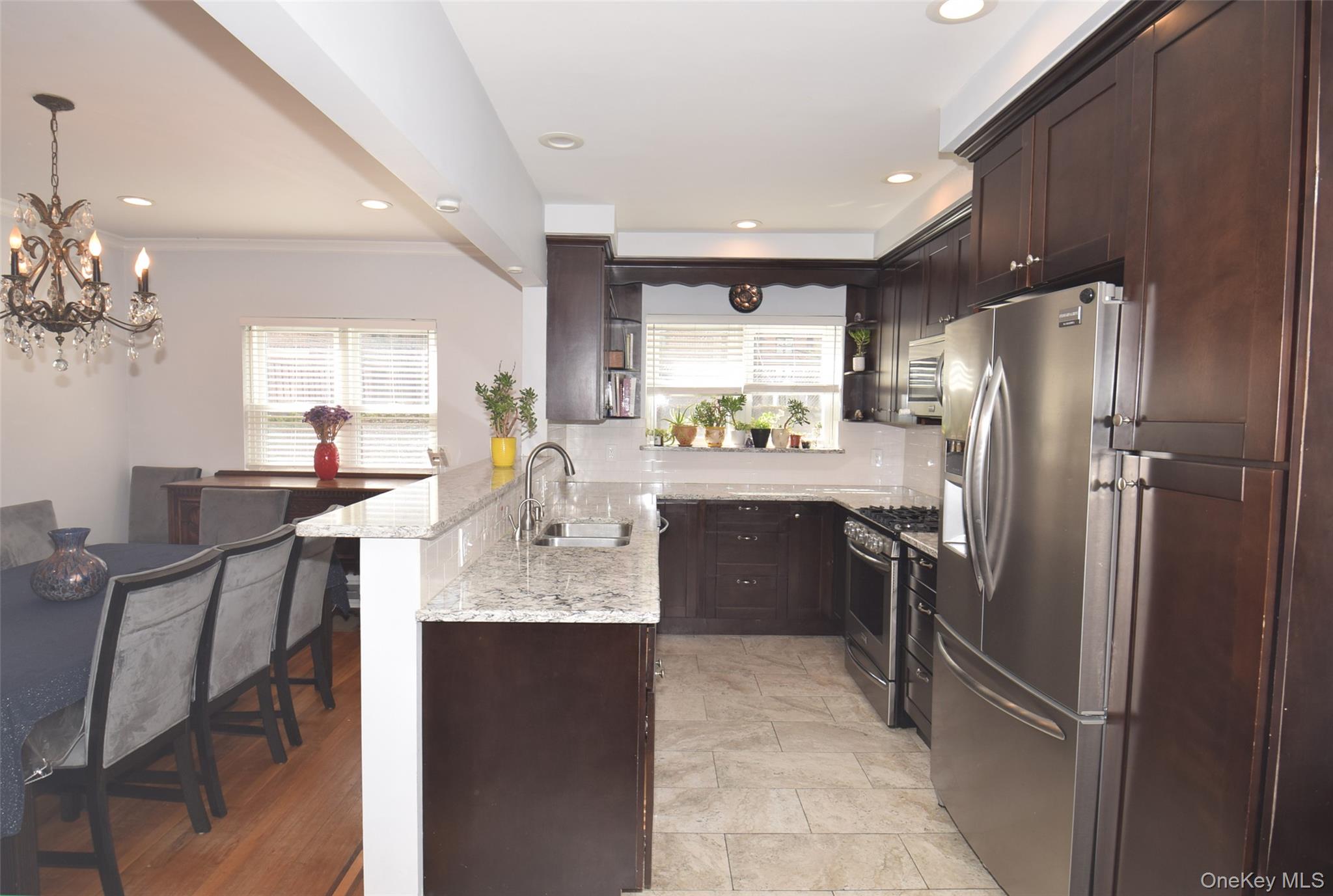 105-48 65th Road Queens, NY 11375 - Photo 7 of 17 a kitchen with kitchen island granite countertop cabinets a refrigerator and a sink