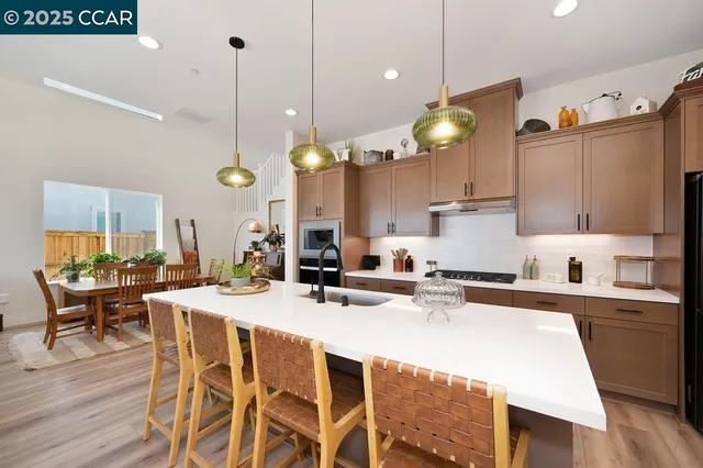 a kitchen with a dining table chairs sink and cabinets