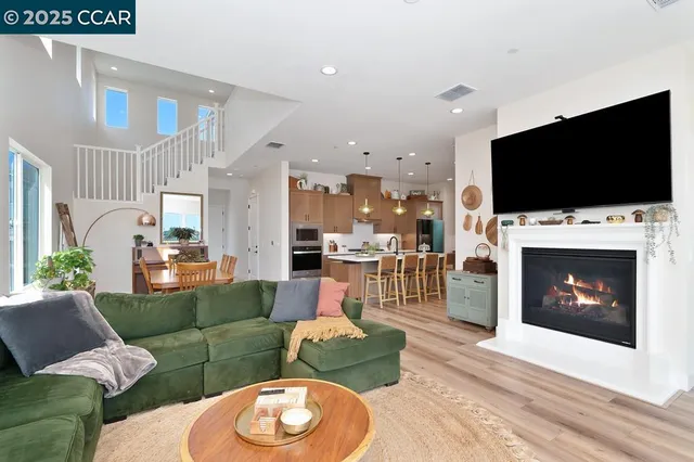 a living room with furniture a flat screen tv and a fireplace