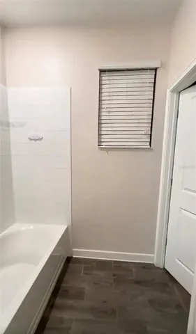 a view of bathroom with bathtub and wooden floor