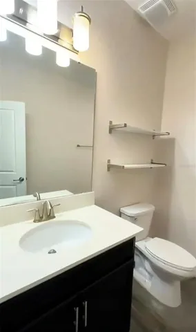 a bathroom with a sink a toilet a mirror and vanity
