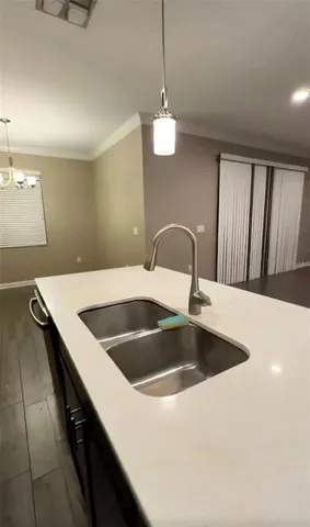a kitchen with a sink and chandelier