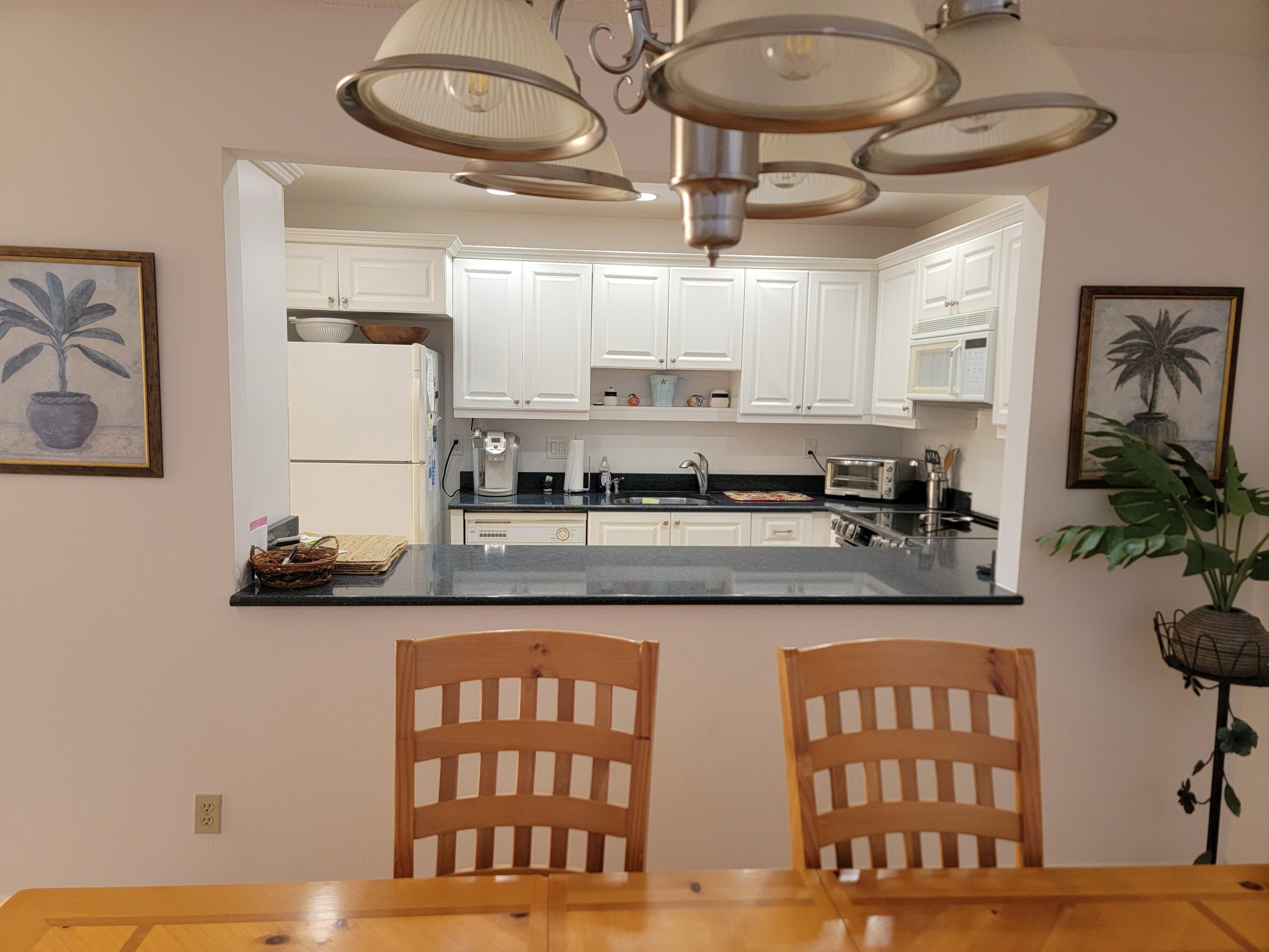 11115 Oakdale Road Boynton Beach, FL 33437 - Photo 13 of 30 a kitchen with stainless steel appliances granite countertop a stove and cabinets