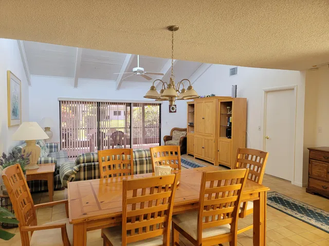 a view of a dining room with furniture large windows and wooden floor