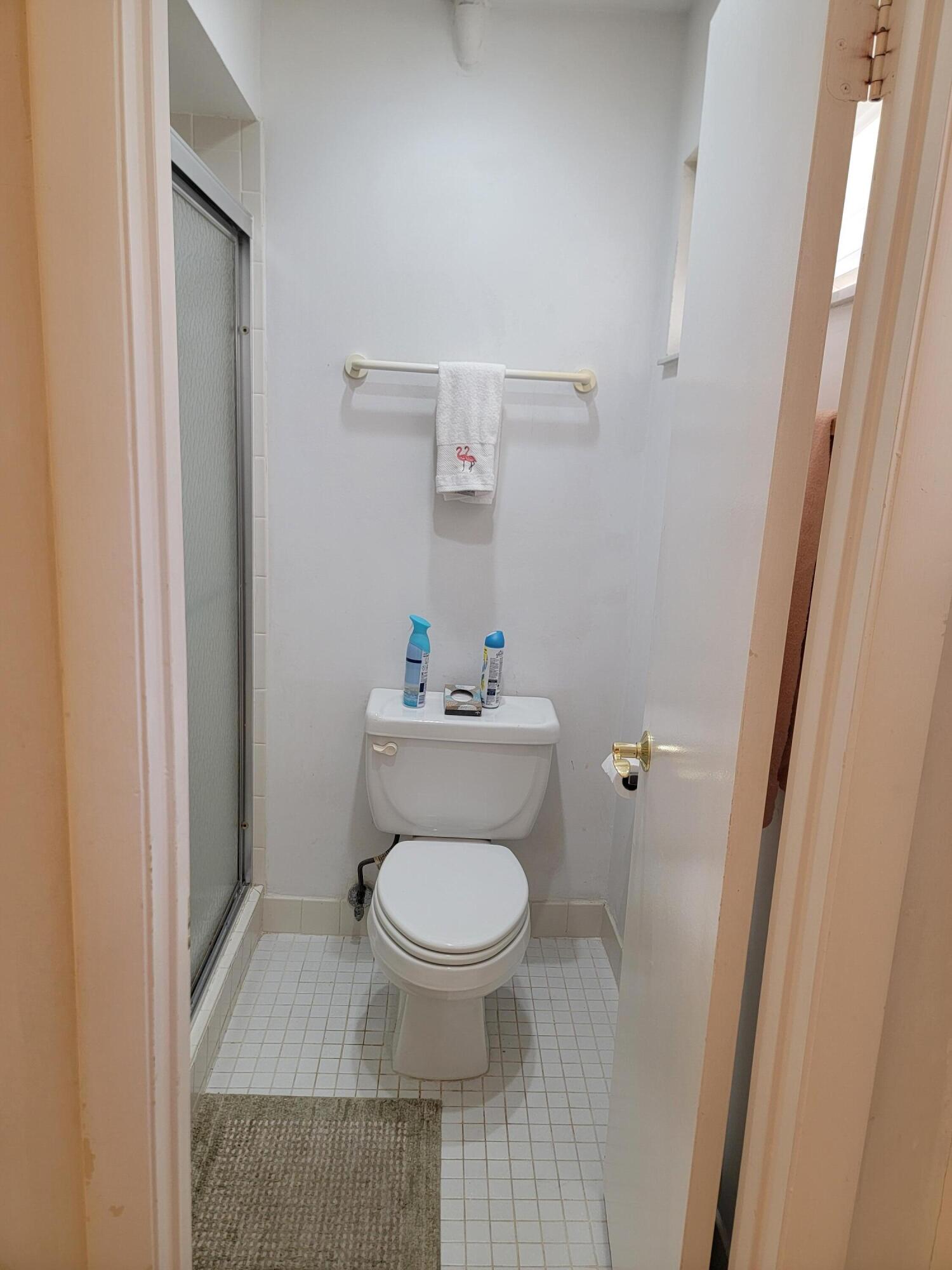 11115 Oakdale Road Boynton Beach, FL 33437 - Photo 26 of 30 a white toilet sitting next to a sink and vanity