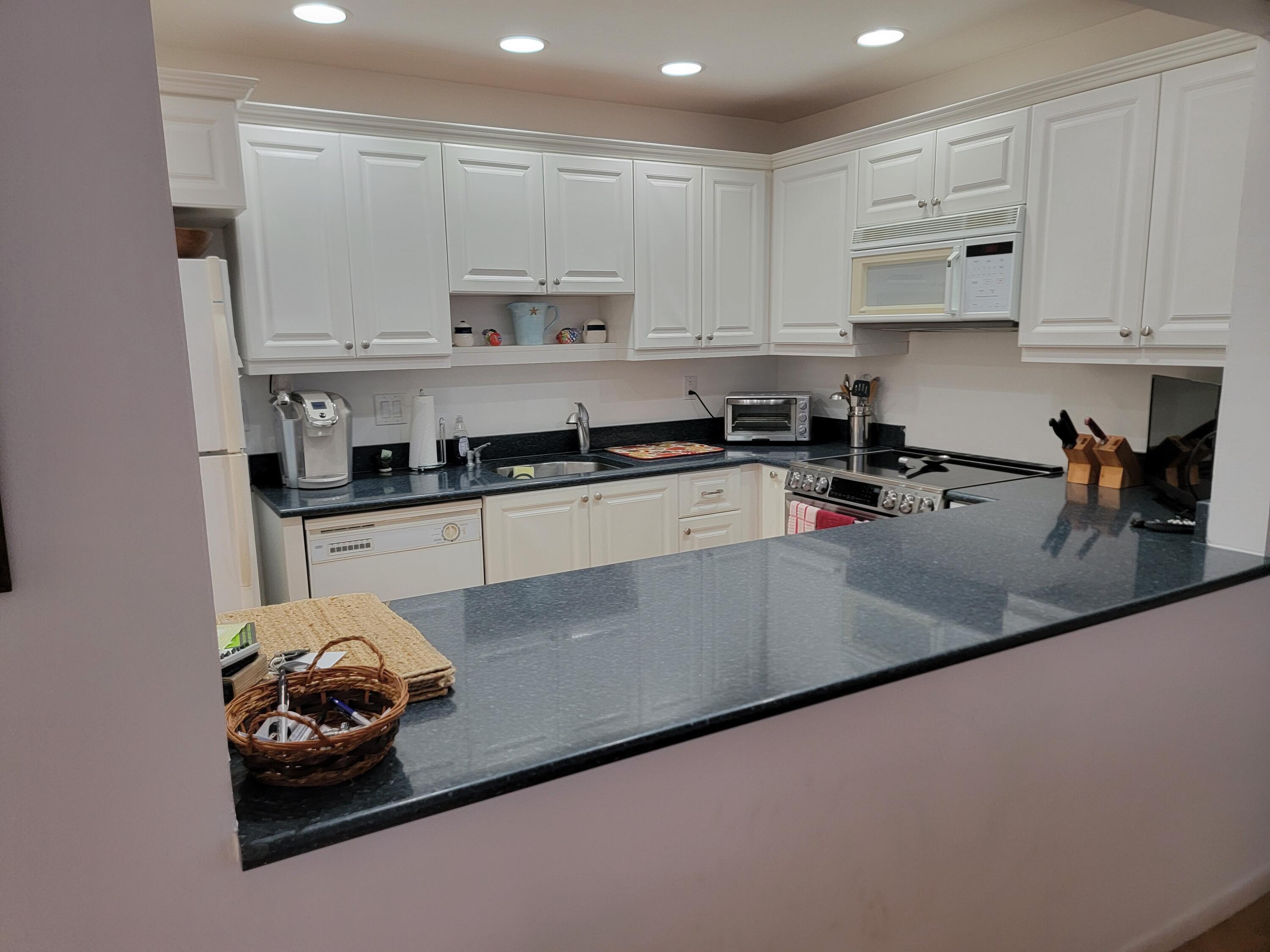 11115 Oakdale Road Boynton Beach, FL 33437 - Photo 28 of 30 a kitchen with stainless steel appliances granite countertop a sink a stove and cabinets