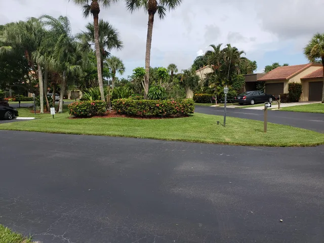 a front view of a house with garden and trees