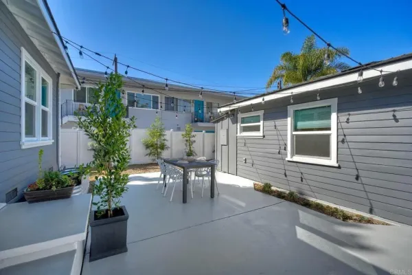a backyard of a house with a table and chairs
