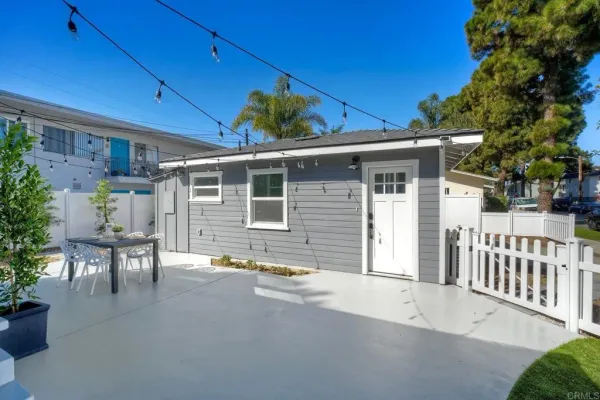 a view of a house with backyard and sitting area