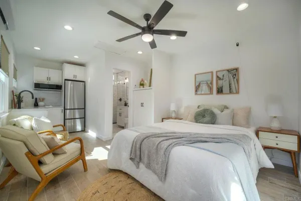 a spacious bedroom with a bed mirror and couch
