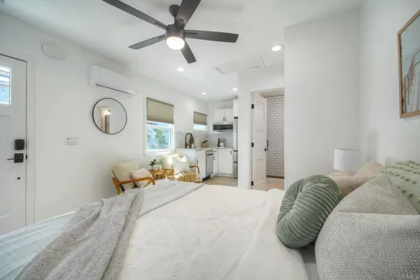 a spacious bedroom with a bed and ceiling fan