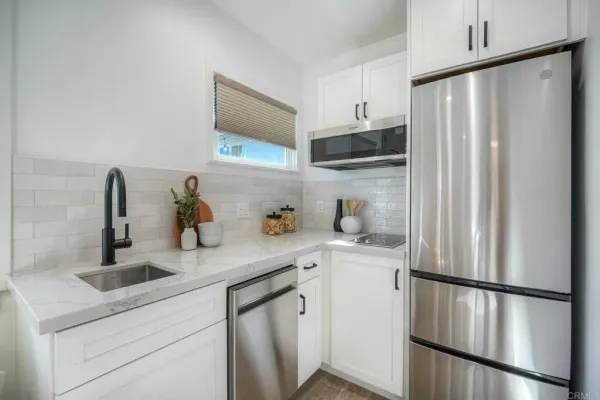 a kitchen with stainless steel appliances a refrigerator sink and cabinets