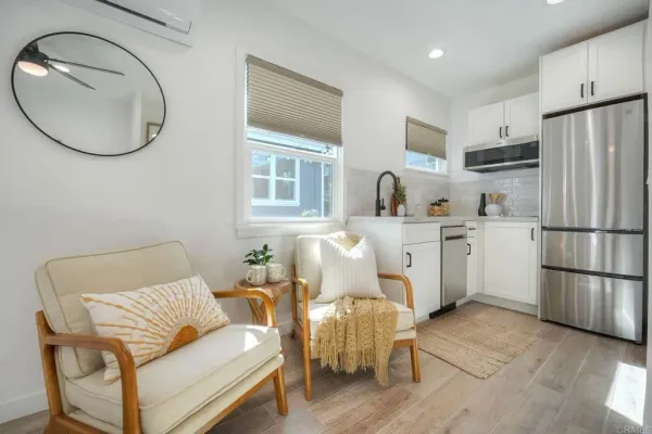 a living room with furniture a flat screen tv and a window