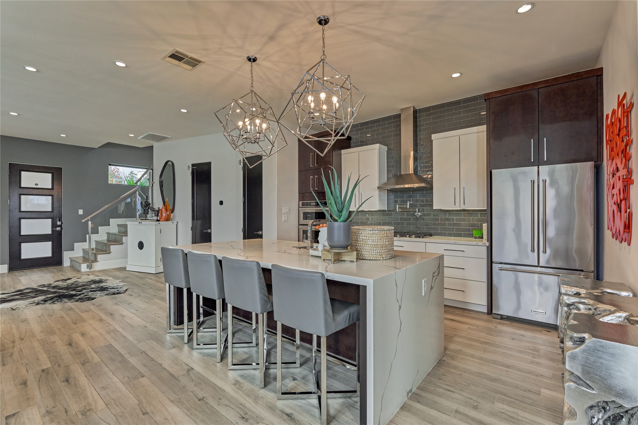 189 Stevinstraat Montgomery, TX 77356 - Photo 17 of 50 a kitchen with stainless steel appliances kitchen island granite countertop a refrigerator a stove a dining table and chairs with wooden floor