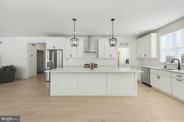 a kitchen with stainless steel appliances granite countertop a sink a stove top oven a counter space and cabinets