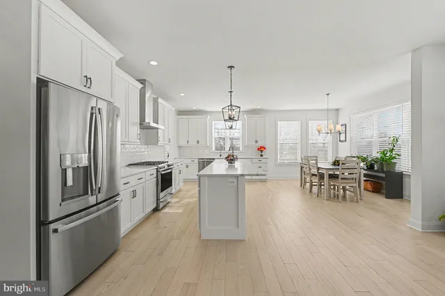 a kitchen with stainless steel appliances granite countertop a sink and a dining table