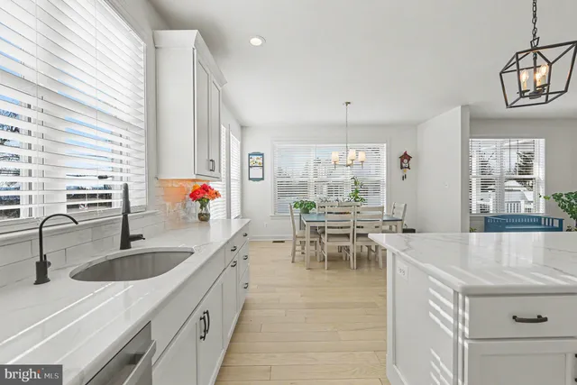 a kitchen that has a lot of white cabinets and couches