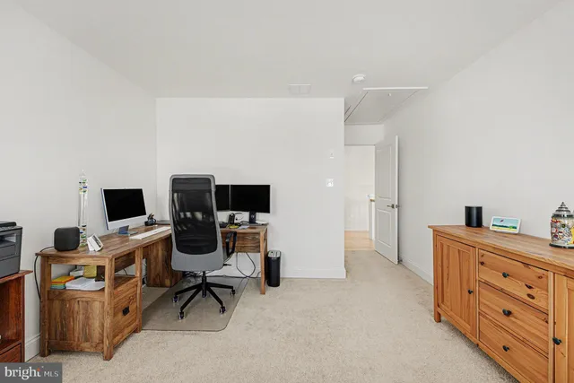 a view of a workspace with furniture and a window