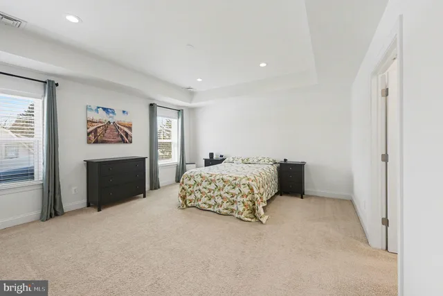 a spacious bedroom with a bed and a cabinets